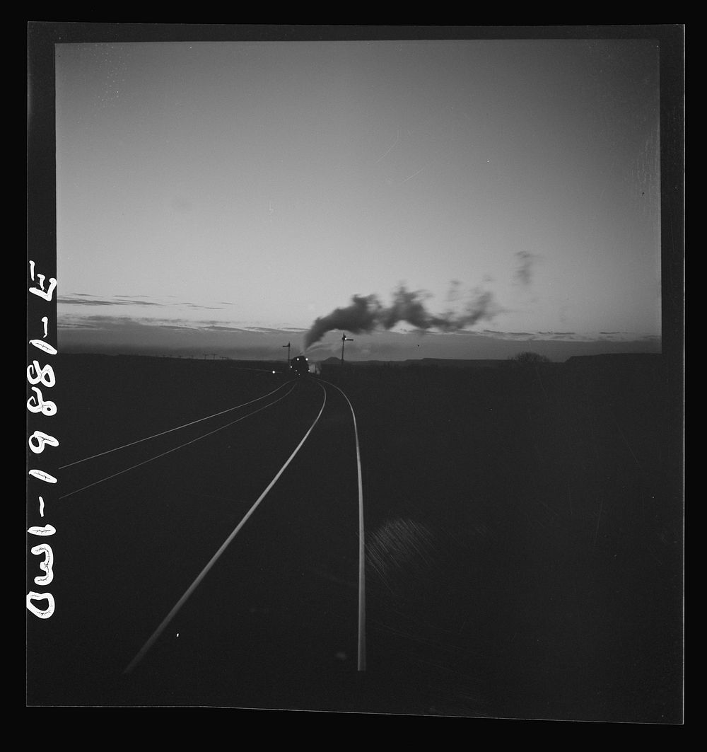 Belva, Oklahoma. Helper engine coming to help push the train on the Atchison, Topeka, and Santa Fe Railroad as far as…