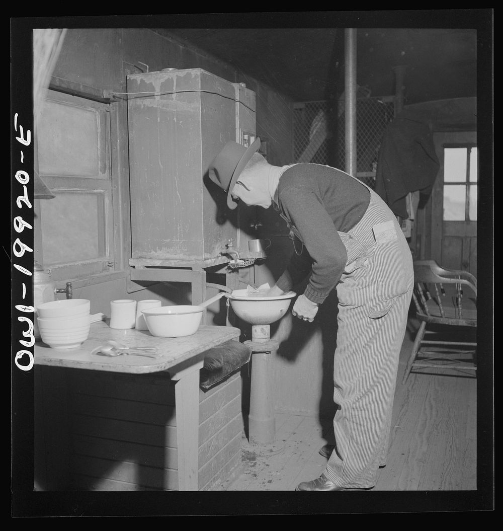Brakeman Jack W. Torbet of Waynoka, Oklahoma washing dishes after having had lunch in the caboose on the Atchison, Topeka…