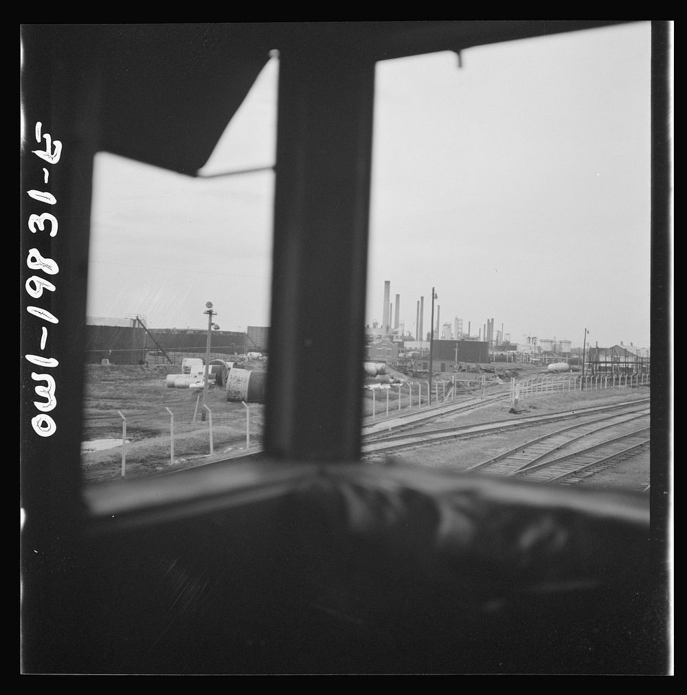 Wellington, Kansas. An oil refinery seen through the windows of the cupola of the caboose on the Atchison, Topeka, and Santa…