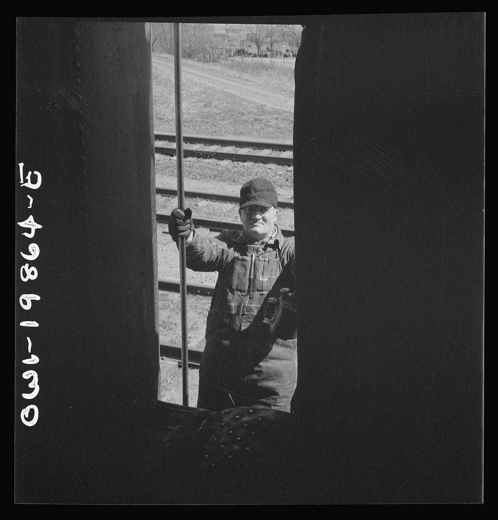 Kiowa, Kansas. Engineer B. F. Hale climbing back into the locomotive as the train is about to start on the Atchison, Topeka…