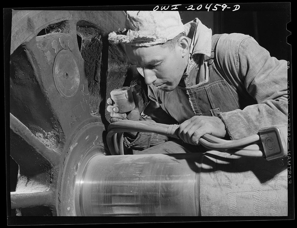 Albuquerque, New Mexico. Magnaflux inspector A.J. Fry at work on an engine wheel axle in the Atchison, Topeka and Santa Fe…