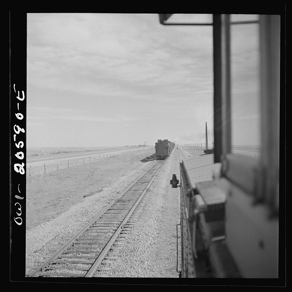 Parmerton, Texas. Passing an eastbound freight train on the Atchison, Topeka and Santa Fe Railroad between Amarillo, Texas…