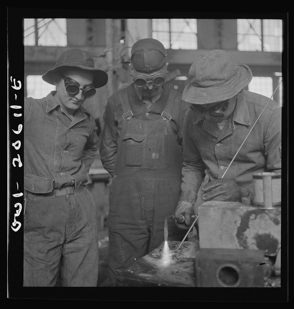 Clovis, New Mexico. Soldiers of the United States Army Railroad Battalion study welding at the locomotive shops in the…