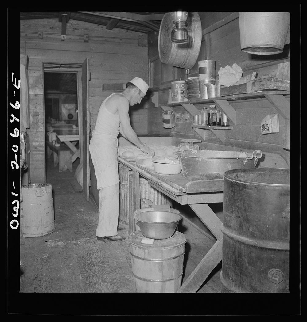 Iden, New Mexico. Baking bread in the kitchen car of the work train on the Atchison, Topeka and Santa Fe Railroad yard…
