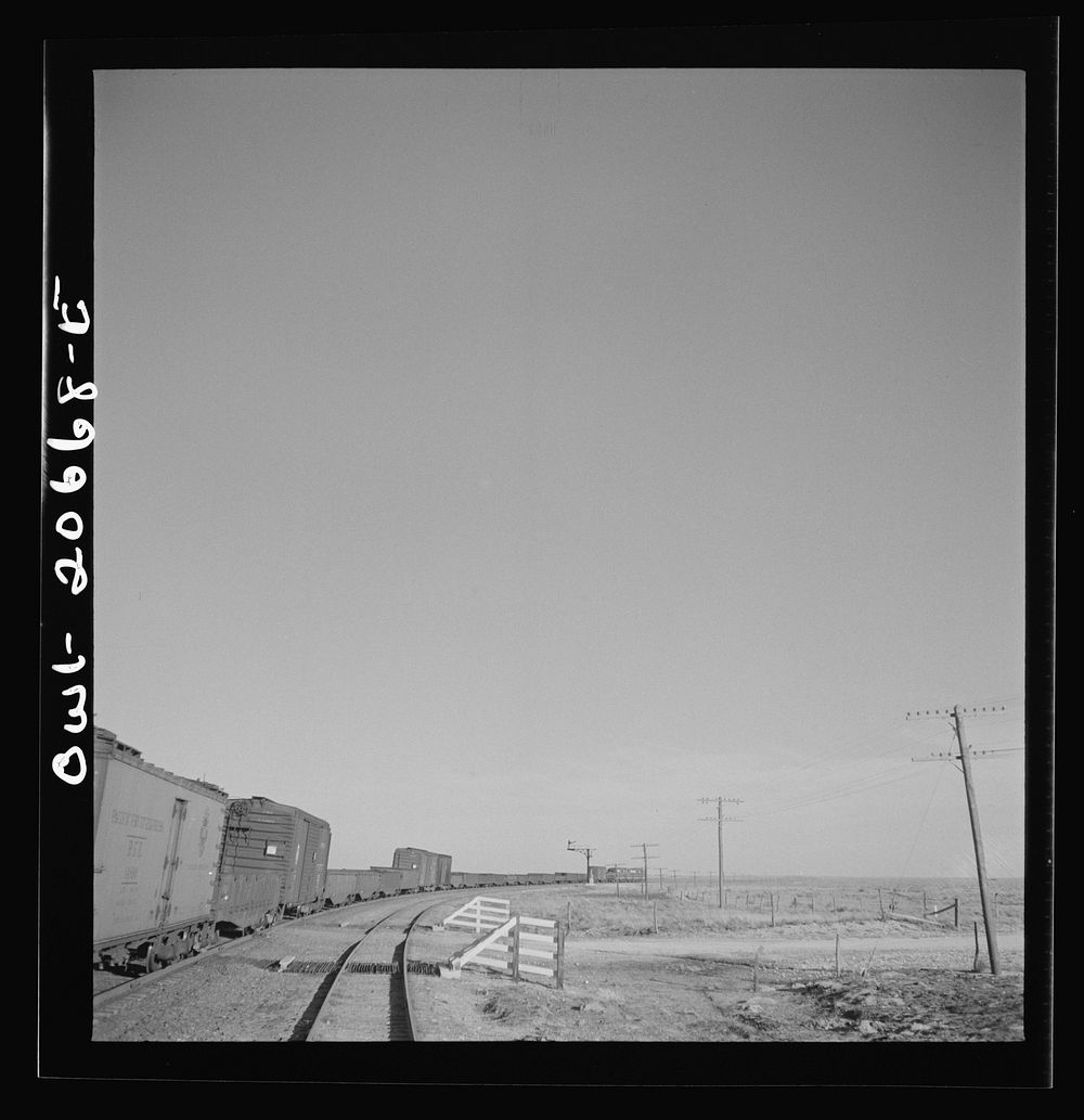 [Untitled photo, possibly related to: Buchanan, New Mexico. Passing an eastbound diesel freight train along the Atchison…