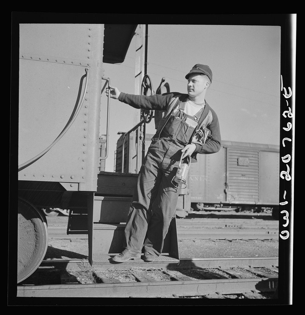 Belen, New Mexico. A brakeman on the Atchison, Topeka and Santa Fe Railroad C.G. Kirkland getting off the caboose. Sourced…