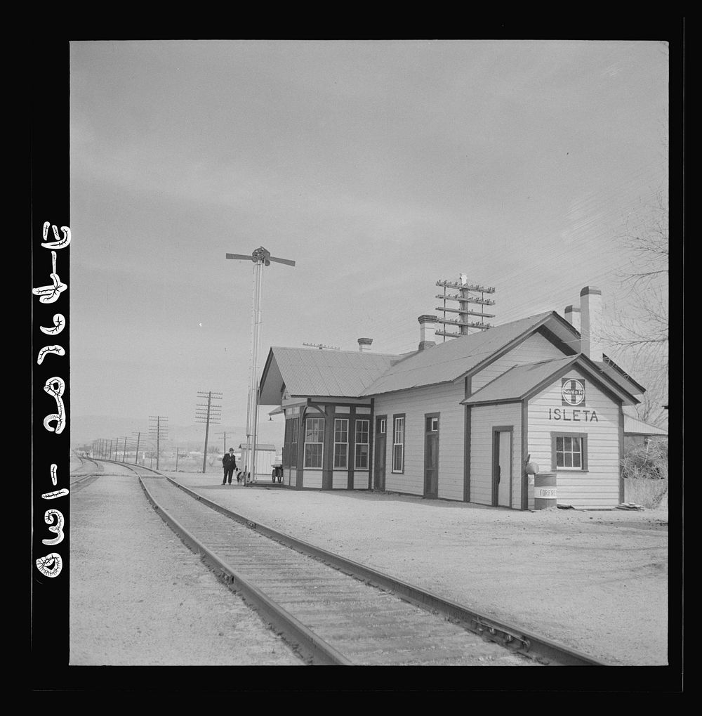 Isleta, New Mexico. The depot. Horizontal arms on pole indicate a "red beard," that is a message is to be picked up by the…