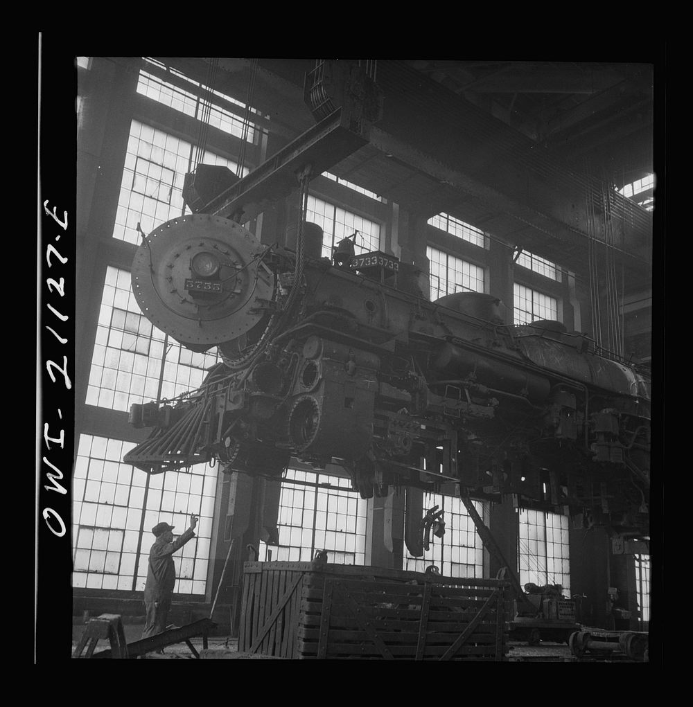 Albuquerque, New Mexico. Lifting an engine to be carried to another part of the Atchison, Topeka and Santa Fe Railroad shops…
