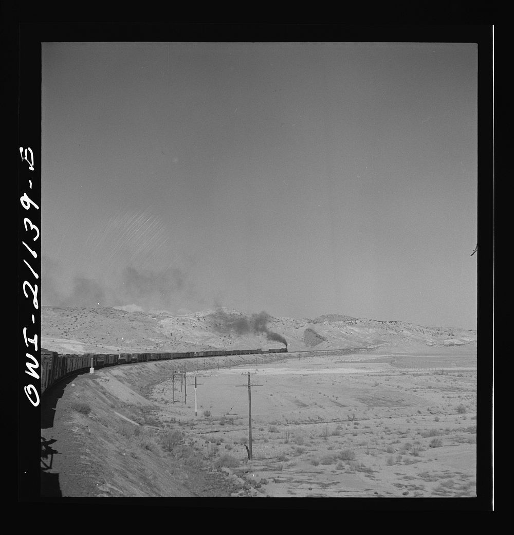 [Untitled photo, possibly related to: Quirk (vicinity), New Mexico. A train rounding a curve along the Atchison, Topeka and…