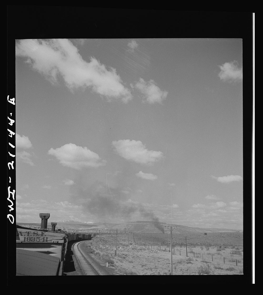 [Untitled photo, possibly related to: Quirk (vicinity), New Mexico. A train rounding a curve along the Atchison, Topeka and…