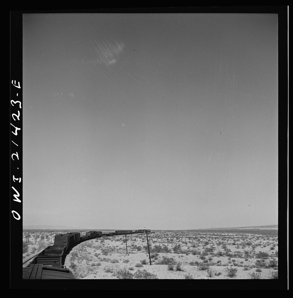 [Untitled photo, possibly related to: Goffs (vicinity), California. A diesel freight train going around a curve on the…