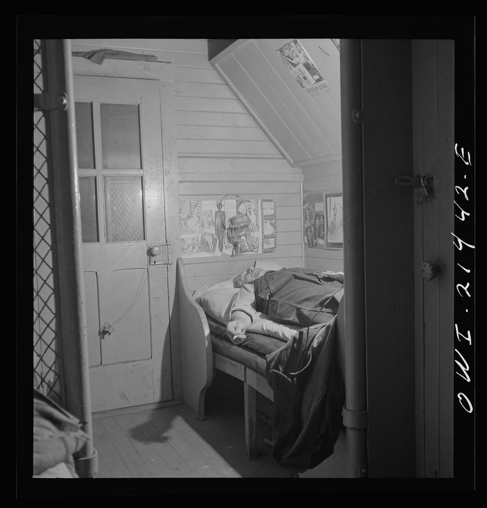 Barstow, California. A brakeman on the Atchison, Topkea and Santa Fe Railroad resting in his caboose at night. Sourced from…