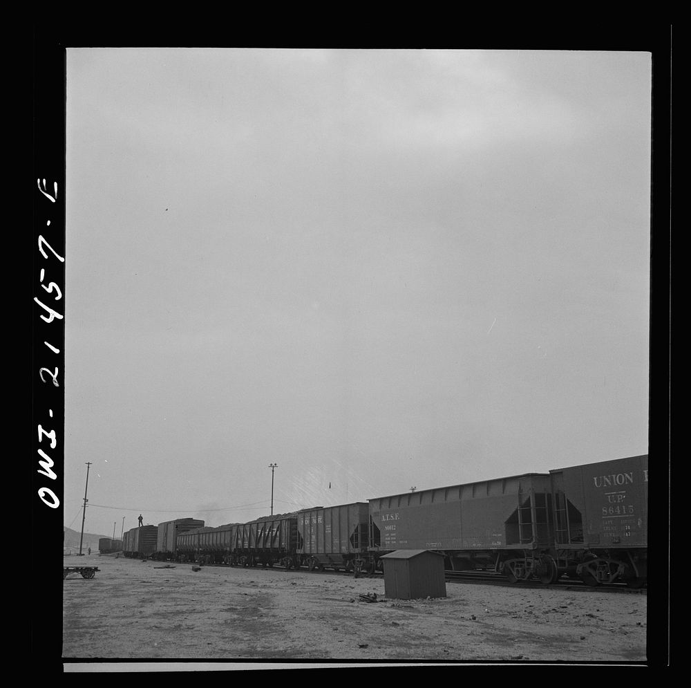 Barstow, California. B.E. Wilson, a brakeman on the Atchison, Topeka and Santa Fe Railroad, waiting for his train to leave.…