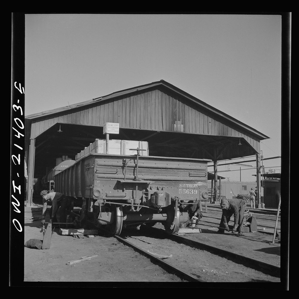 [Untitled photo, possibly related to: Needles, California. Workmen jacking up a car at the rip tracks in the Atchison…