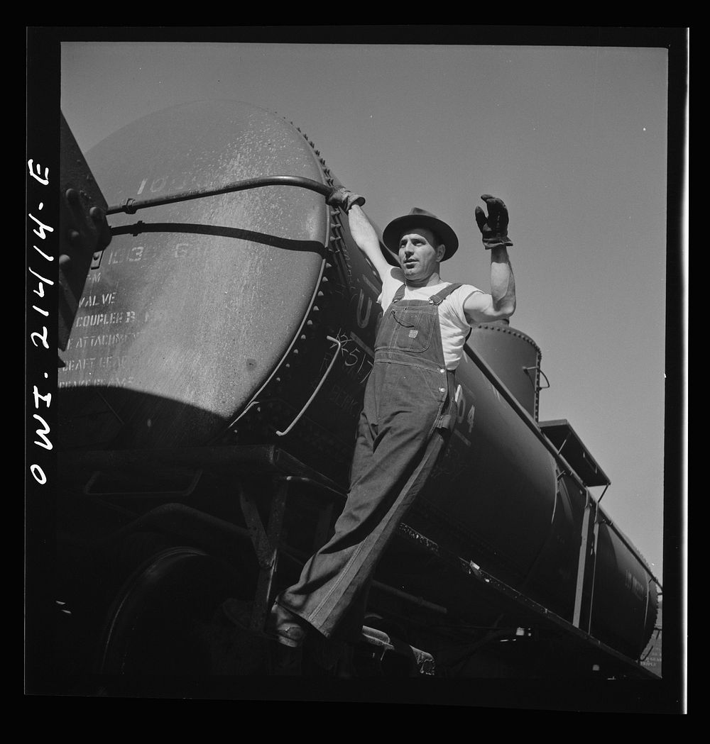 Needles, California. Switchman W.E. McCaniel at work in the Atchison, Topeka, and Santa Fe Railroad yard. Sourced from the…