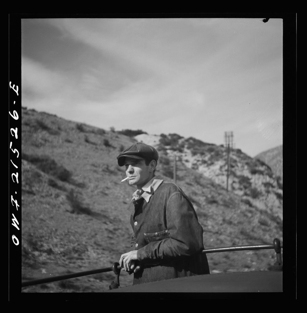 Brakeman H.B. Van Santford riding on top of the caboose as the train on the Atchison, Topeka, and Santa Fe Railroad goes…