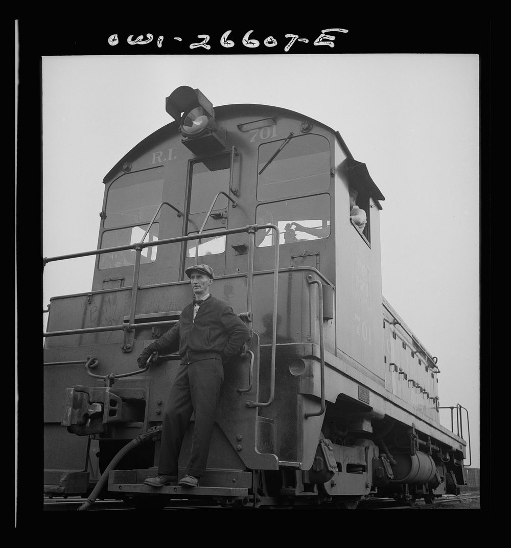 Blue Island, Illinois. Switchman riding the footboard of a diesel switch engine on the Chicago and Rock Island Railroad.…