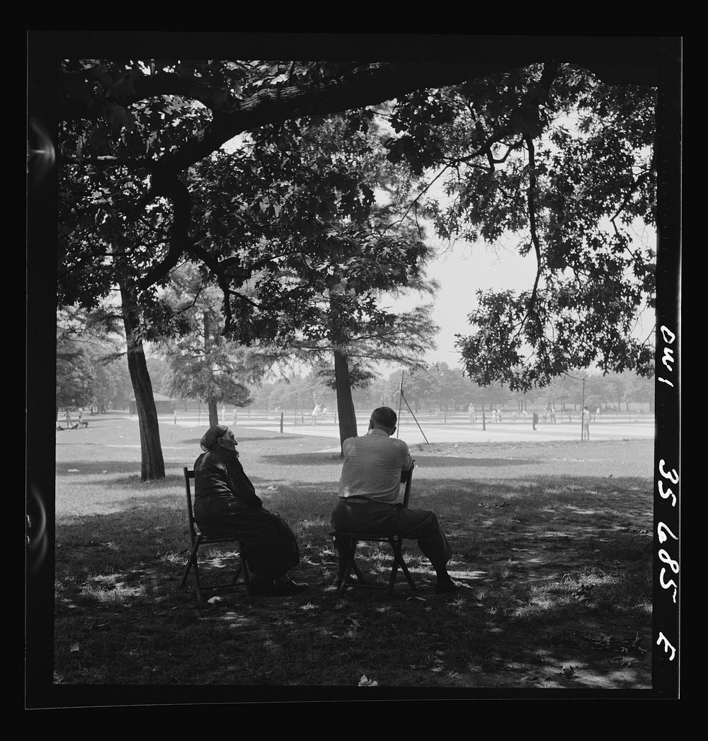 Philadelphia, Pennsylvania. Watching the tennis players from the shade of the trees in Fairmont Park. Sourced from the…