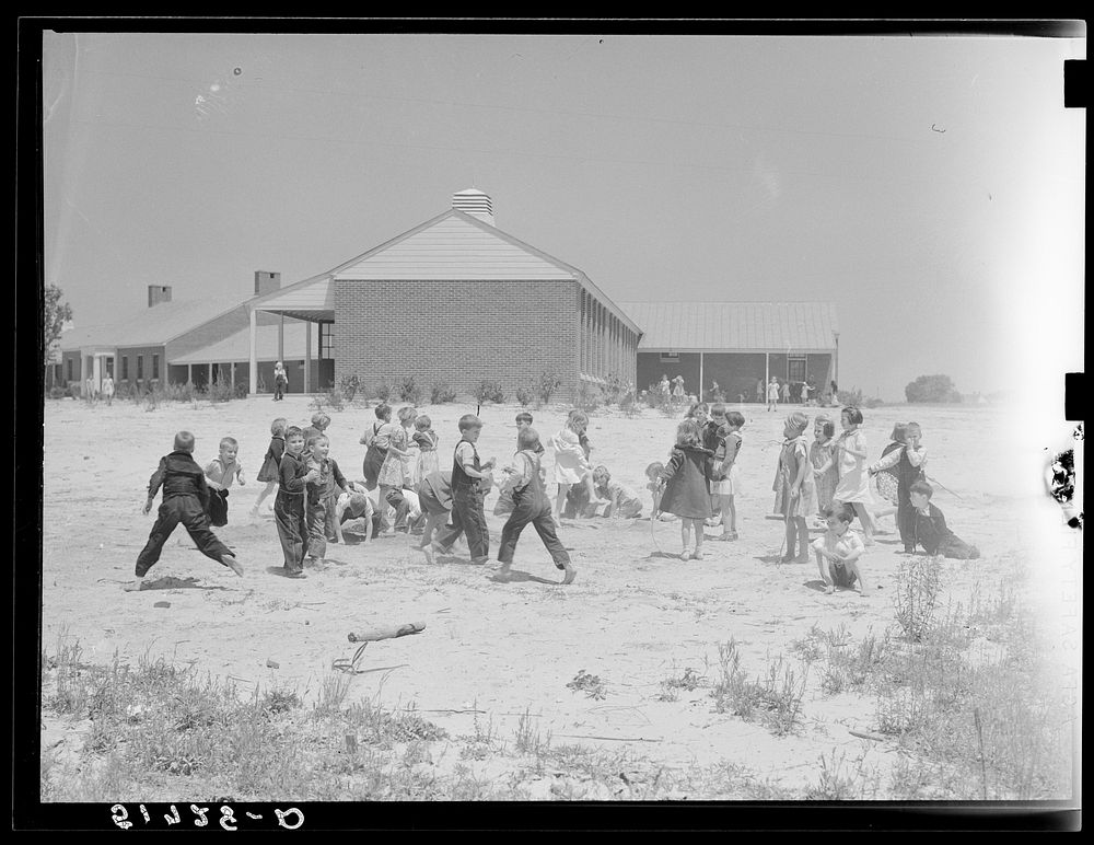 Second grade children playing near school building. Ashwood Plantations, South Carolina. Sourced from the Library of…
