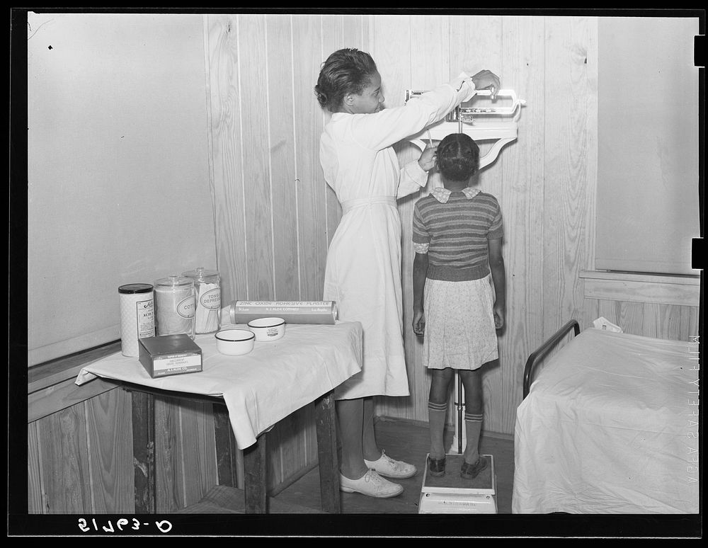 Child being weighed and examined in health room. Prairie Farms, Alabama. Sourced from the Library of Congress.