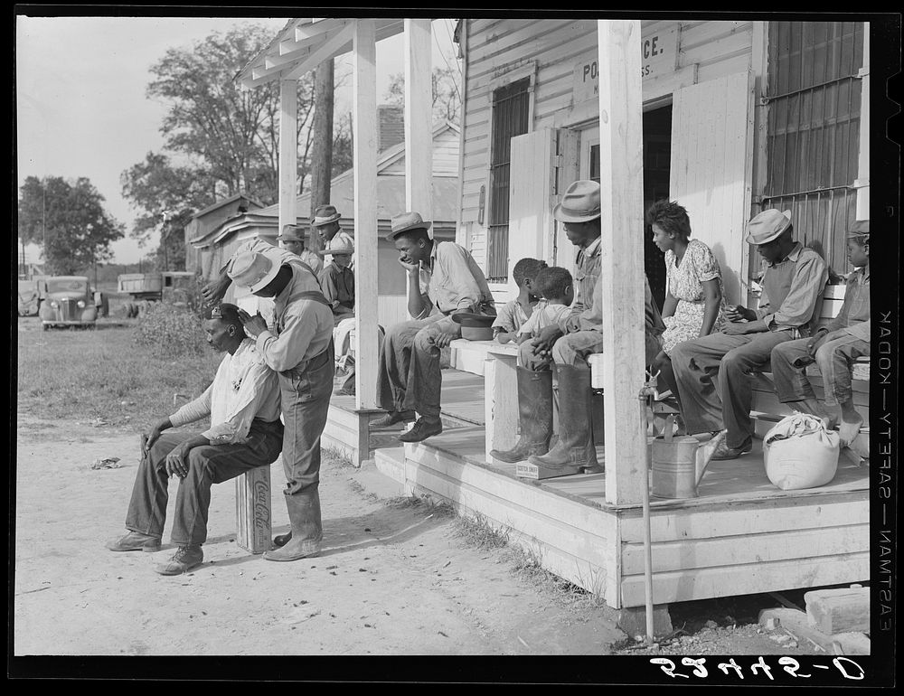 [Untitled photo, possibly related to: es cut each other's hair in front of plantation store after being paid off on…