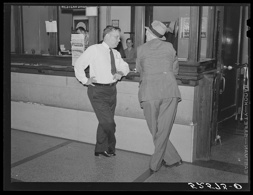 President of Memphis cotton exchange discussing business with one of the members on the floor. Sourced from the Library of…