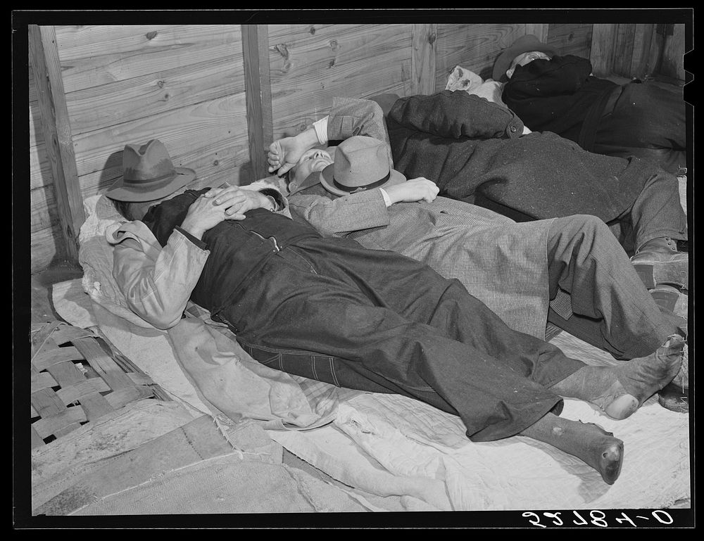 Farmers sleeping in white camp room in warehouse. They often must remain overnight or several days before their tobacco is…
