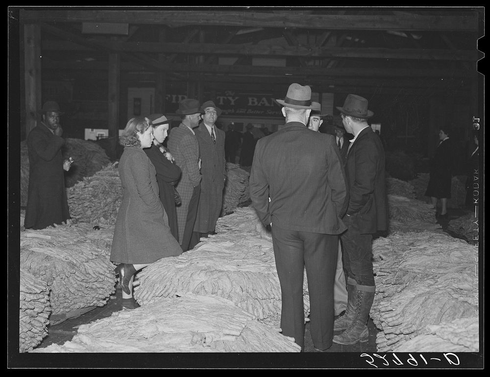 [Untitled photo, possibly related to: Auctioneer, buyers, and farmers during tobacco auction sale. Warehouse, Durham, North…