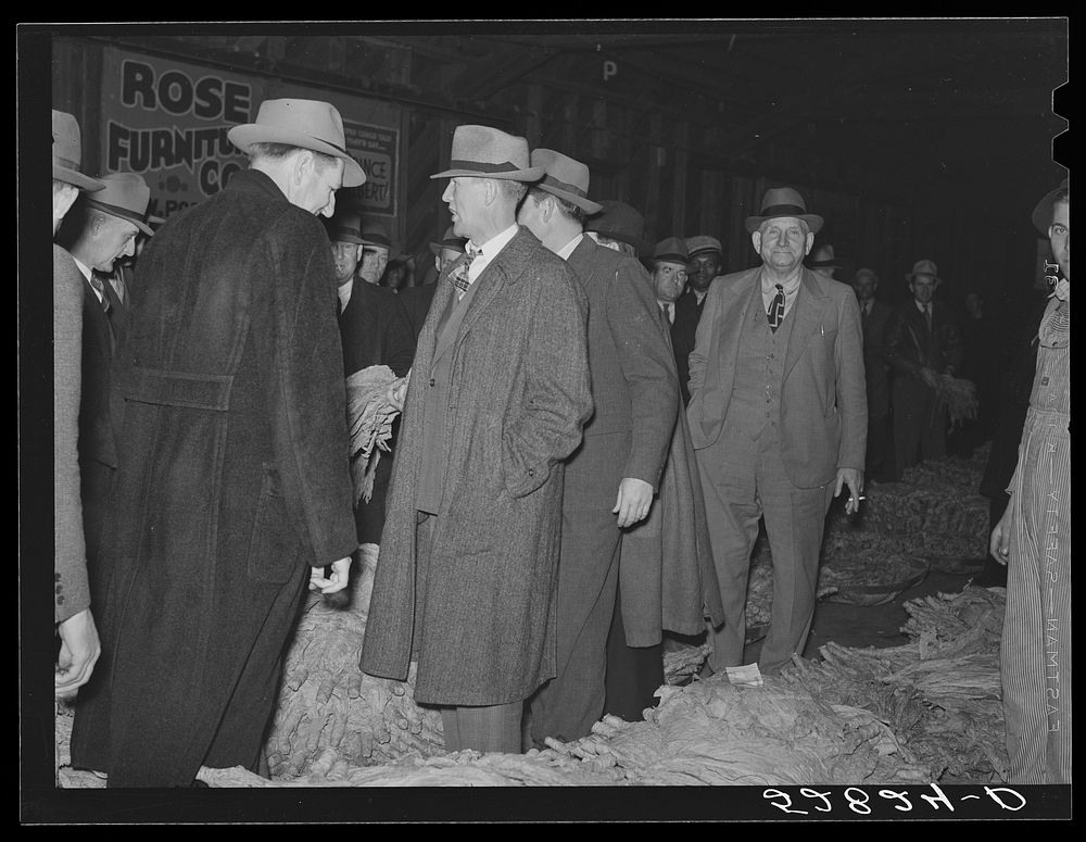 Auctioneer and buyers in warehouse during sale of tobacco. Durham, North Carolina. Sourced from the Library of Congress.
