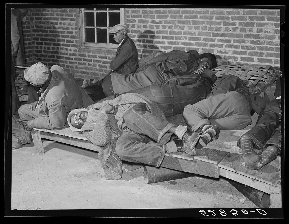 Farmers sleeping in  camp room in warehouse. They often must remain overnight or several days before their tobacco is…