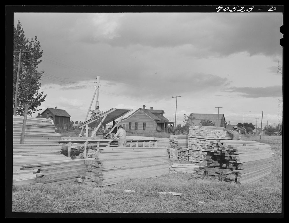 Sawing lumber to length for construction of sanitary units at the FSA (Farm Security Administration) trailer camp at…