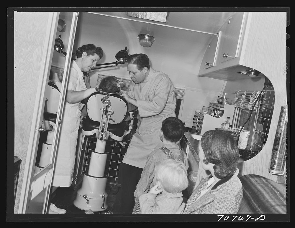 FSA (Farm Security Administration) dentist and migrant child in the FSA dental trailer at the FSA camp for farm families.…