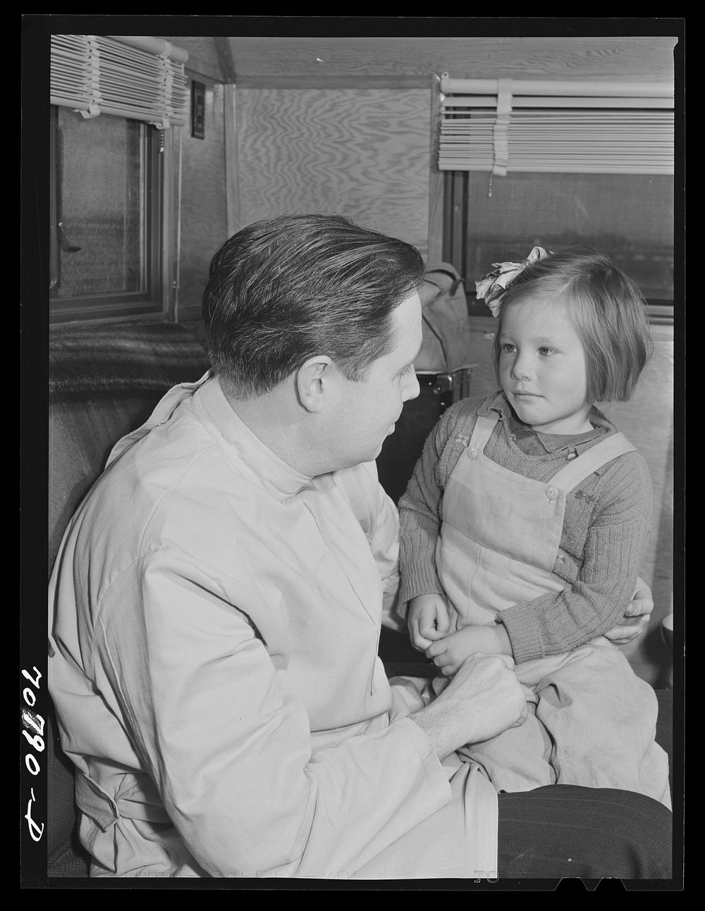 FSA (Farm Security Administration) dentist reassures migrant child who is making her first visit to a dentist. FSA dental…