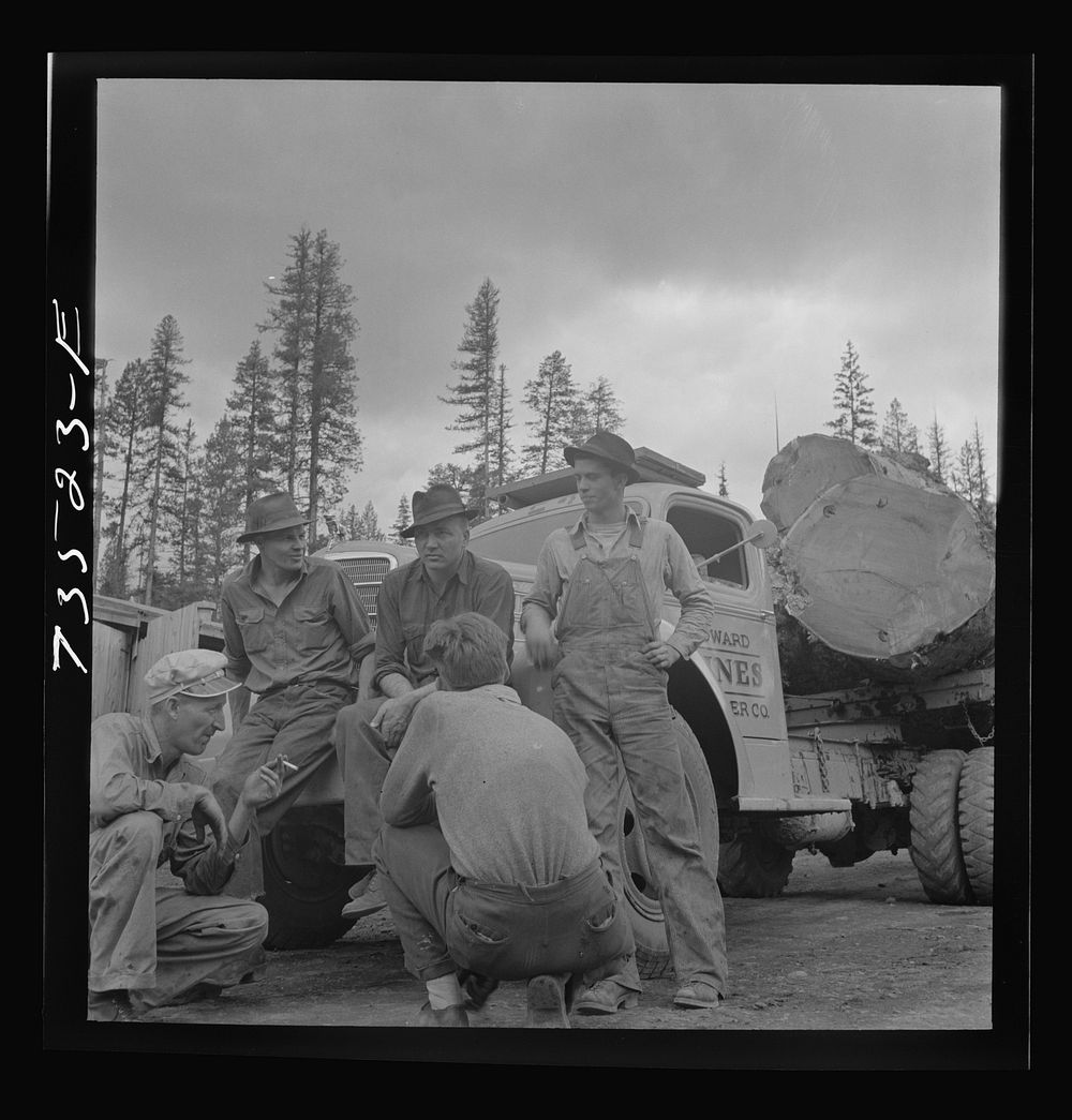 Grant County, Oregon. Malheur National Forest. Lumberjacks and truckload of logs by Russell Lee