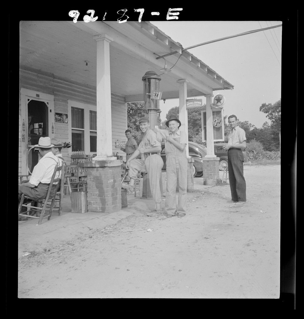 [Untitled photo, possibly related to: Rural filling station becomes community center and general grounds for loafing. The…