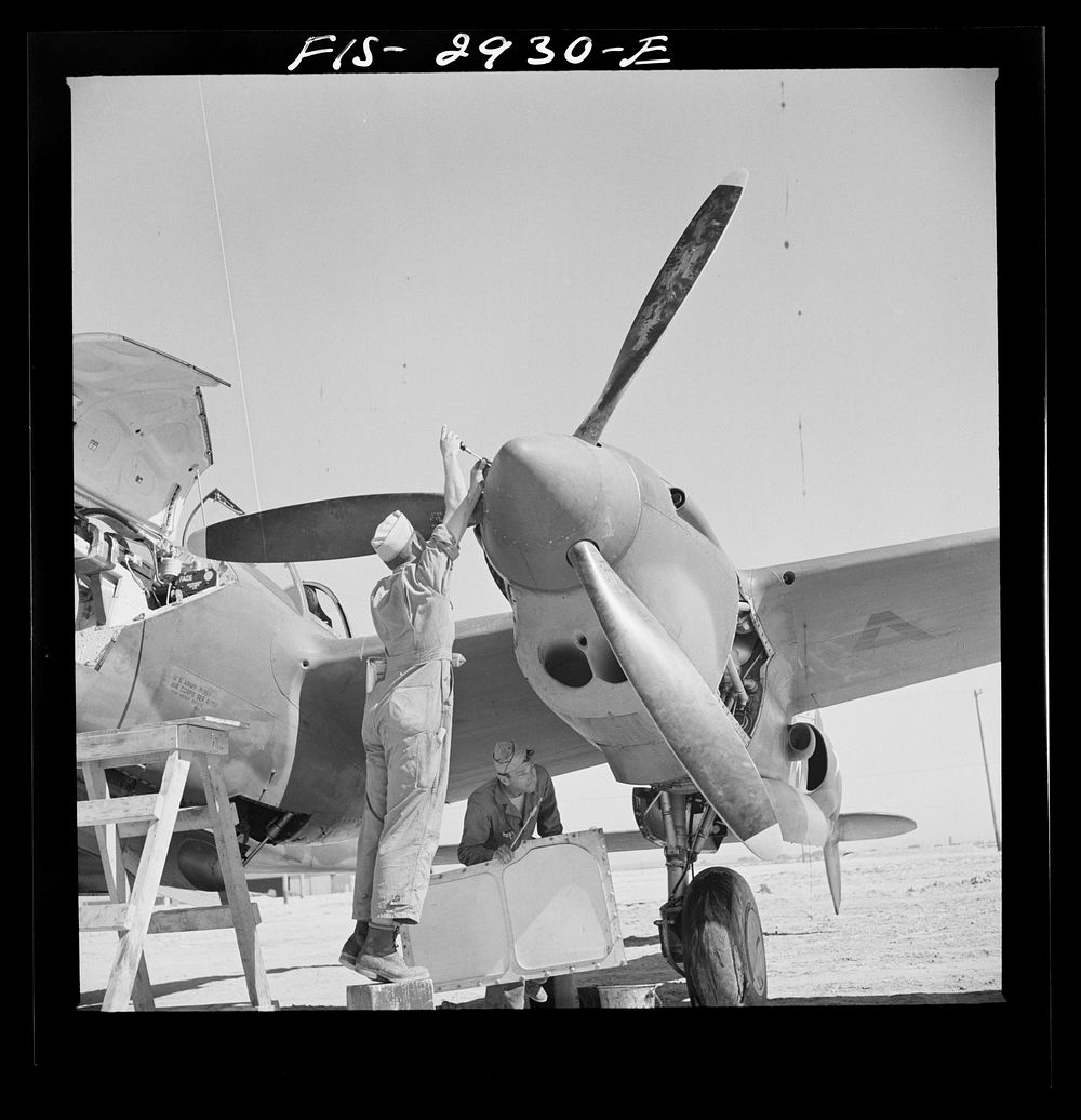 [Untitled photo, possibly related to: Replacing propeller hub of interceptor plane. Lake Muroc, California] by Russell Lee