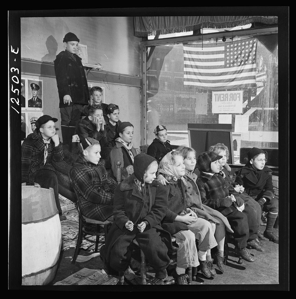 Chicago (north), Illinois. Children assembled in Office of Civilian Defense headquarters for a pep talk on the need of…