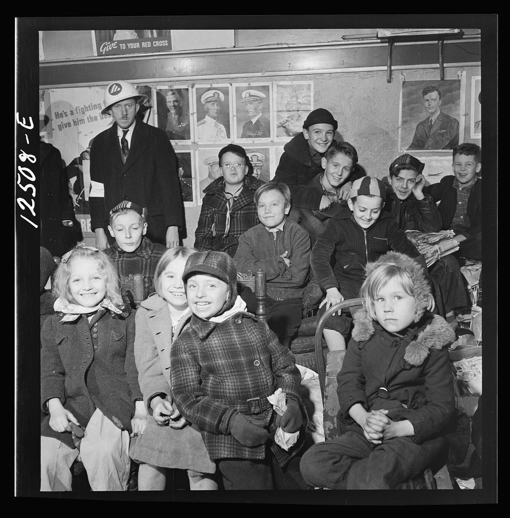 Chicago (north), Illinois. Children assembled in Office of Civilian Defense headquarters for a pep talk on the need of…