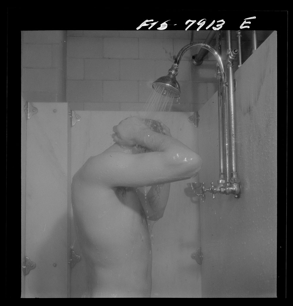 [Untitled photo, possibly related to: Fort Belvoir, Virginia. Sergeant George Camblair taking a shower before dinner at…
