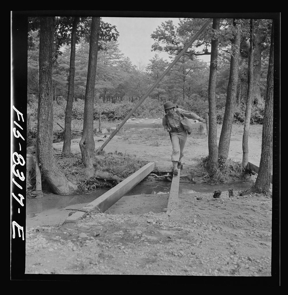 Fort Belvoir, Virginia. Sergeant George Camblair getting rigorous physical training on the obstacle course. Sourced from the…
