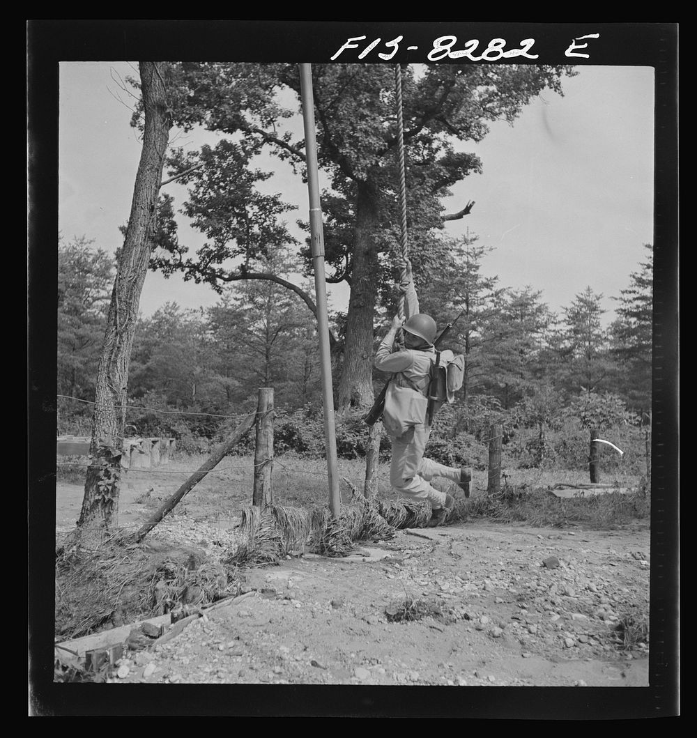Fort Belvoir, Virginia. Sergeant George Camblair getting rigorous physical training on the obstacle course. Sourced from the…