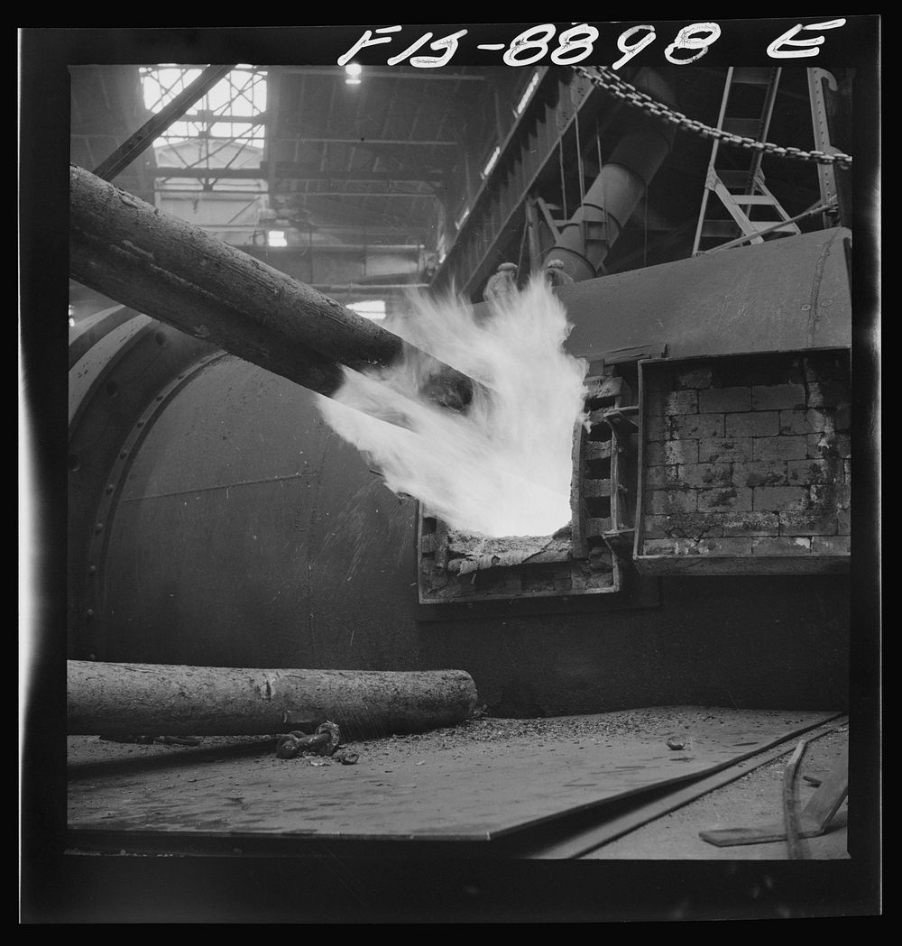 Anaconda smelter, Montana. Anaconda Copper Mining Company. Poling in the refining furnace. Wooden poles are plunged into the…