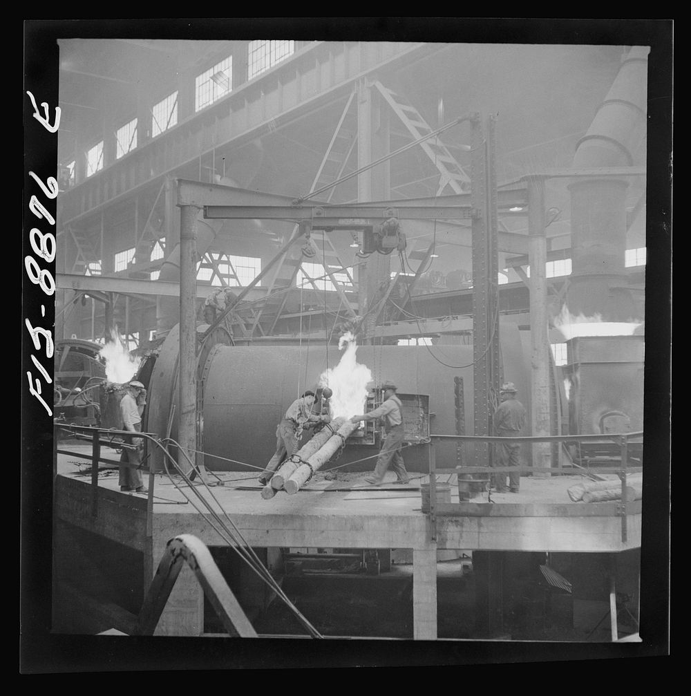 Anaconda smelter, Montana. Anaconda Copper Mining Company. Poling in the refining furnace. Wooden poles are plunged into the…