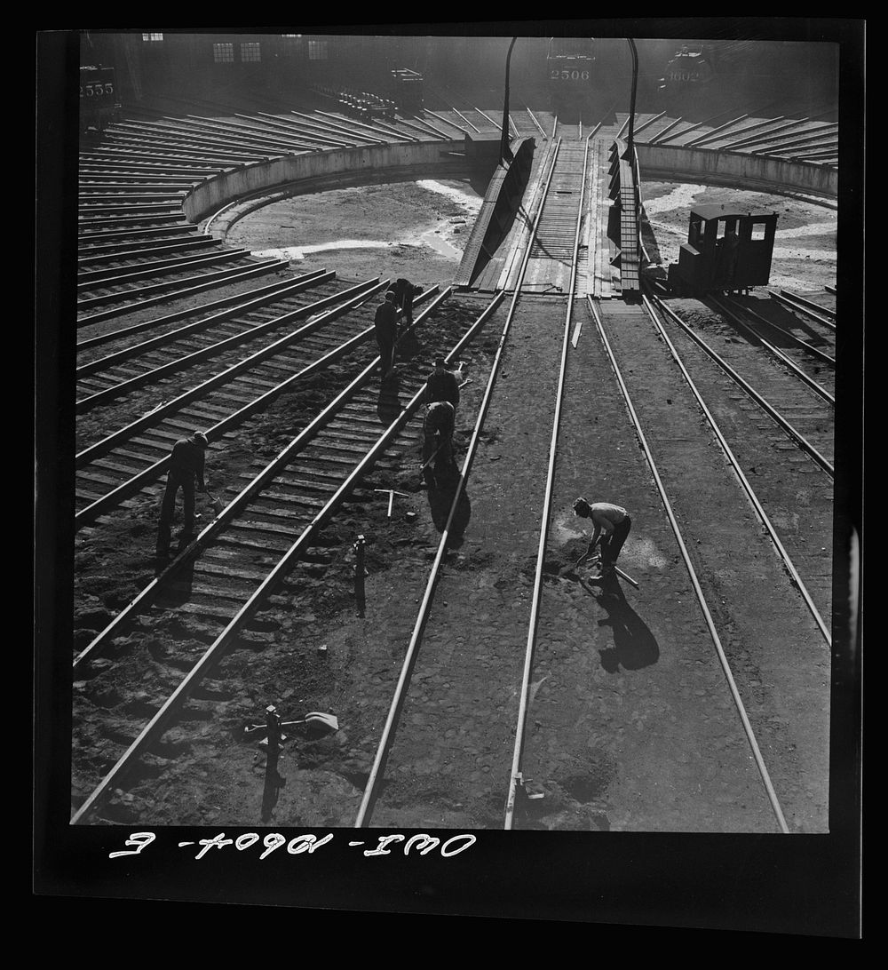 Chicago, Illinois. Track crews repairing tracks in the roundhouse at an Illinois Central Railroad yard. Sourced from the…