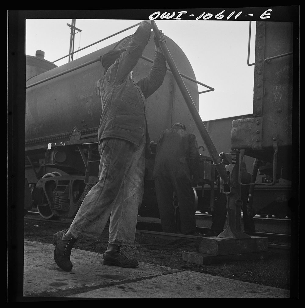 [Untitled photo, possibly related to: Chicago, Illinois. Jacking up a car on the repair tracks at an Illinois Central…