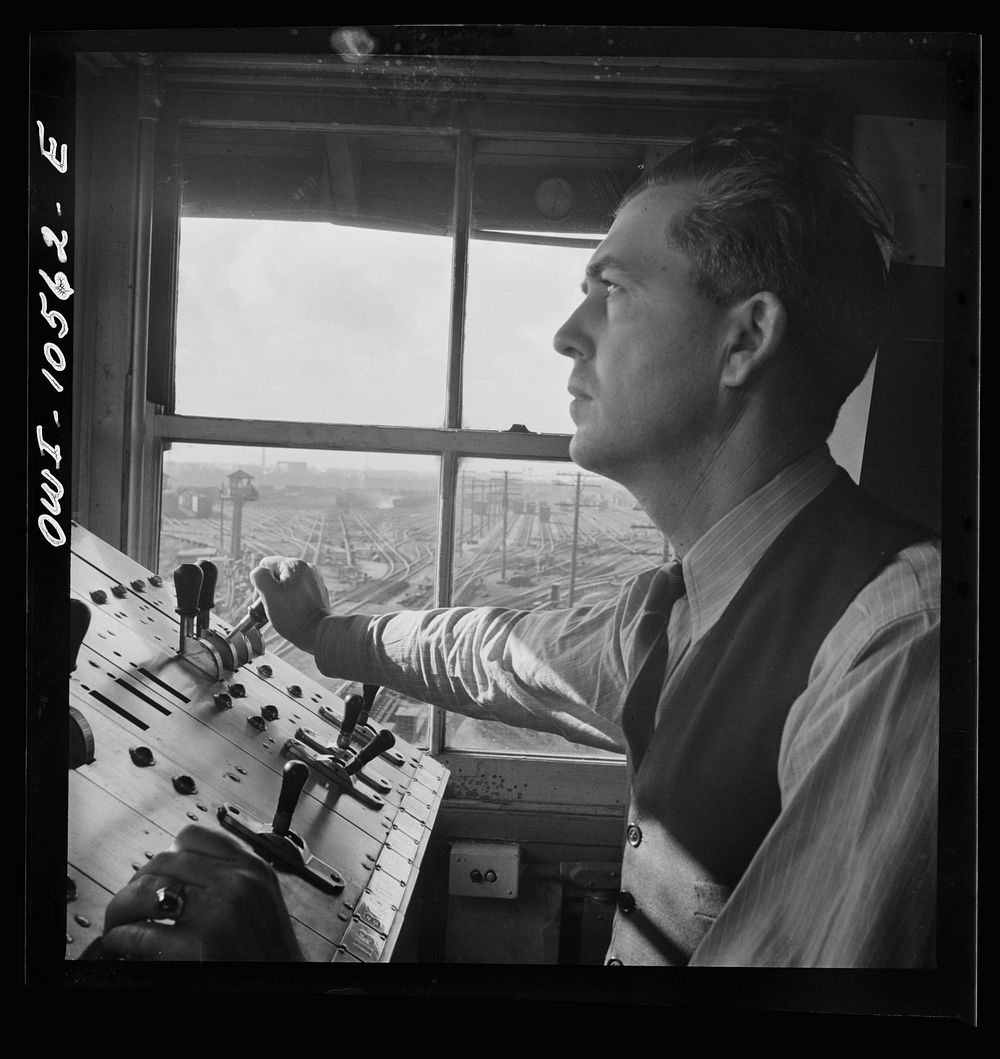 Chicago, Illinois. A retarder operator at the south hump at an Illinois Central Railroad yard. From his control board he…