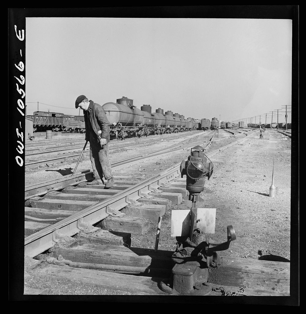 Chicago, Illinois. One of the yard gang cleaning out switches at an Illinois Central Railroad yard. Sourced from the Library…