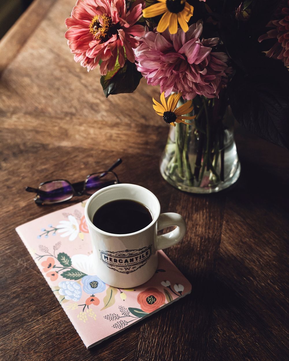Free black coffee, flowers, vase on wooden table photo, public domain beverage CC0 image.