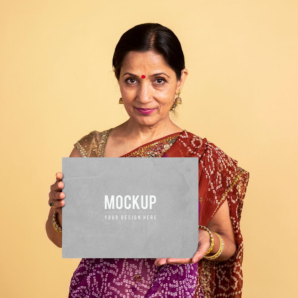 Indian woman in a traditional saree holding a paper mockup 