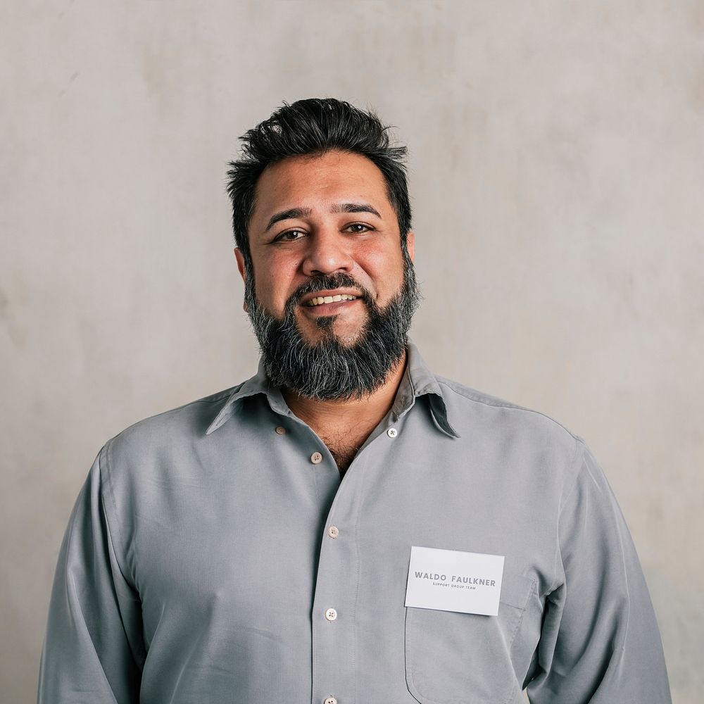 Happy Indian salesman wearing a name tag 